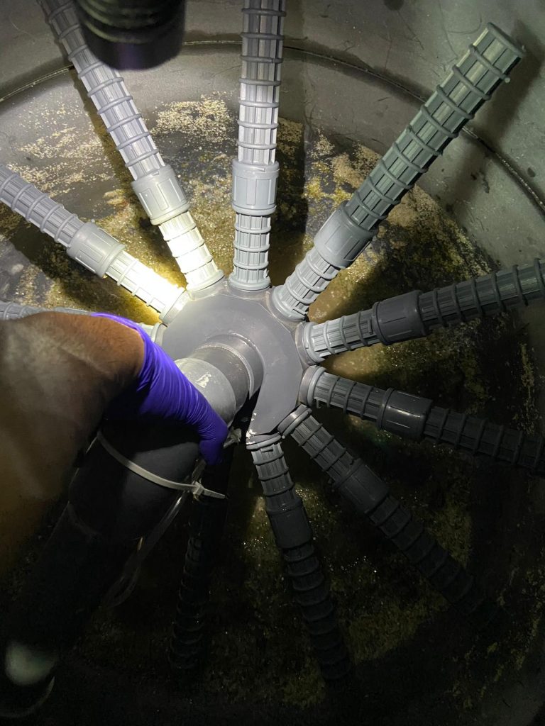 imagen de brazo de persona limpieza el filtro de una piscina
